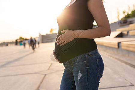 封闭腹室外的孕妇 复制空间 怀孕和孕产概念 以及女性日落微笑公园女孩父母腹部生育力自由母亲图片