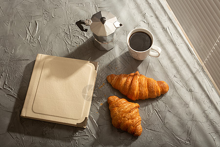 午餐休息概念或开始于上午 但愿早上愉快的咖啡塔克杯和有书在桌上的羊角面包图片