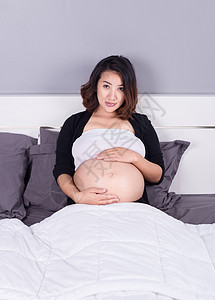 睡在卧室的床上的孕妇倾斜身体女性母亲肚子妈妈母性婴儿腹部生活图片