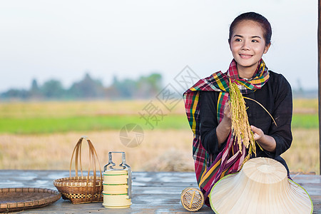 拥有大米和坐在稻田小屋的农民妇女帽子日落收成农业劳动女士腰布微笑文化女性图片