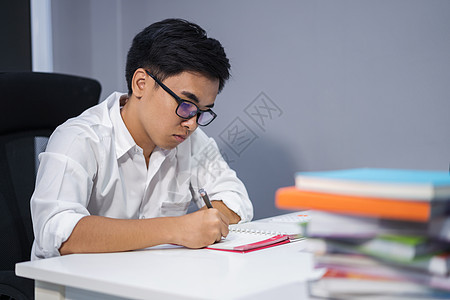 男人在笔记本上学习和写作图片