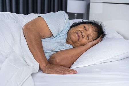 患有失眠症的老太婆想睡在床上孤独说谎失眠头痛卧室女性退休睡眠成人苏醒图片
