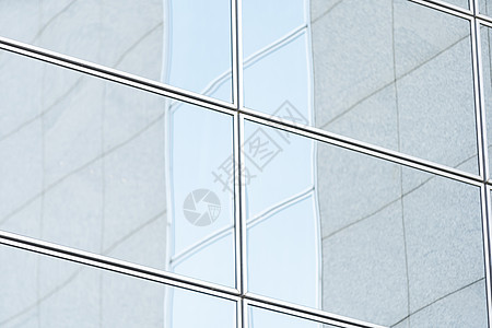 蓝色多云天空下现代玻璃摩天大楼纹理背景的透视和底面视角图片