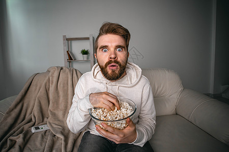 网上看电视系列的人的肖像 在线电影和视频流服务概念 笑声手表客厅学生活动小吃娱乐食物休息遥控男性图片