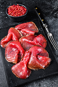 Bresaola治愈了肉牛肉切片 意大利安提帕斯蒂 黑色背景乡村火腿食物烹饪拼盘牛肉小吃红色木板熏制图片