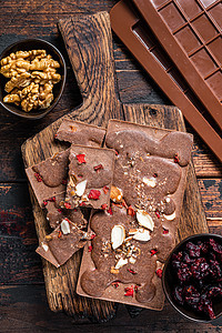 土制木制奶制品巧克力棒 配有栗子 花生 红莓和冻干草莓 黑木本底工艺乡村黑色巧克力褐色食物美食坚果棕色甜点图片