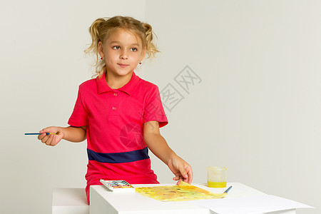 美丽的金发女孩站在桌桌边和水彩绘画幼儿园学习工作室女性工艺教育班级牛仔布童年创造力图片