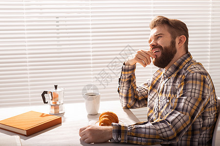 深思熟虑的年轻留胡子男商务人士在百叶窗背景下喝咖啡的侧面景象 上午或午餐休息的概念男人个性男性潮人人士企业家冒充智力衬衫职业图片