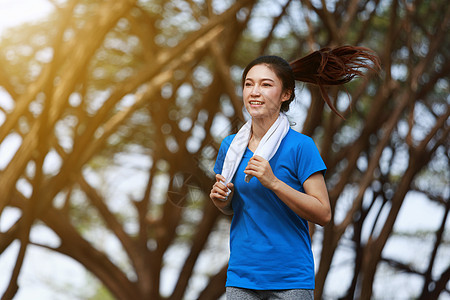 在公园中运行的美丽健身女子赛跑者成人活动街道运动女性运动装训练慢跑者蓝色图片