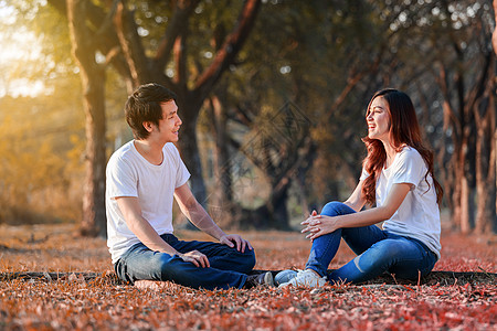 在公园里聊天和拉拉的年轻夫妇图片