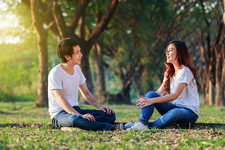 年轻夫妇在公园里聊天和拉拉花园朋友阳光女孩男性乐趣讲话浪漫女士成人图片