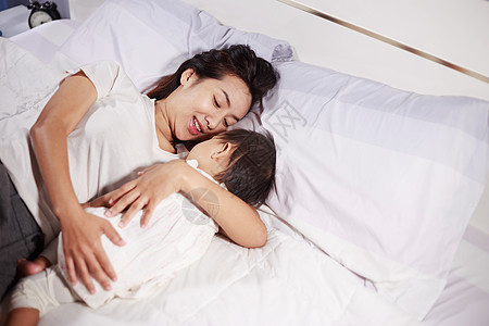 母亲和婴儿睡在家中的床上女性家庭卧室睡眠房间妈妈新生父母说谎母性图片