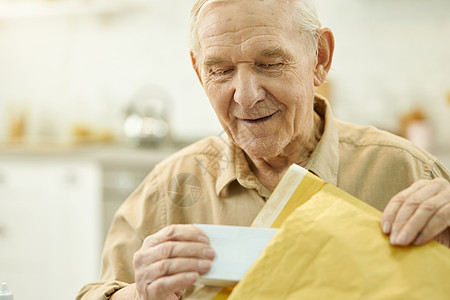 老人在家卸邮包的年长者图片