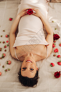 孕妇在肚子附近抱着红玫瑰 作为新生命 幸福 生育的象征 怀孕 孕产 妇科图片