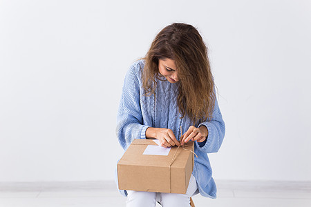 网上购物 送货和时尚概念  坐在家里开始网上服装购买的女性快乐命令顾客电子商务盒子长椅青少年展示销售纸板图片