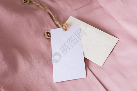 粉红色衬衫上贴着近乎空白的标签 复制空间 广告空间细绳销售摄影纤维店铺衣服装饰风格贸易棉布图片