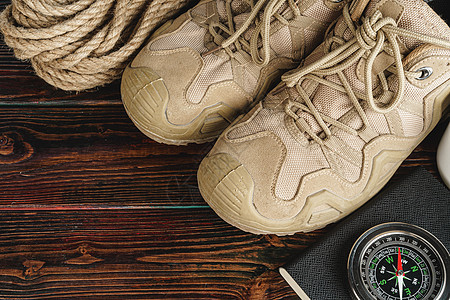 徒步靴子和绳索挂在木板上运动探险家桌子活动荒野登山冒险旅游闲暇森林图片