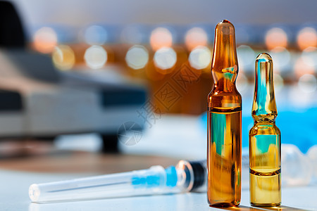 在显微镜照片附近配有药物的医药药瓶玻璃研究实验室玻璃瓶瓶子治疗安瓶药剂安瓿疫苗背景图片