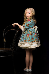 一个女孩的肖像 站在黑色背景上 在老Viennese椅子附近女性幸福童年幼儿园女孩婴儿乐趣喜悦头发牛仔裤图片