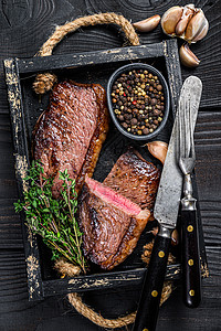 木制托盘中的烧烤烤臀盖或巴西 picanha 牛肉牛排 黑色的木制背景 顶视图木板红色迷迭香食物大理石纹牛肉牛扒草本植物炙烤鱼片图片