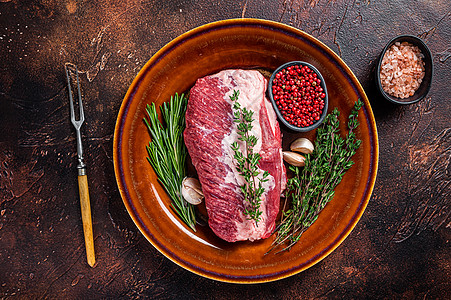 生牛肉肉 烧在有草药的生锈盘子上 深色背景屠夫奶牛大理石纹鱼片胡椒胸部迷迭香白色红色烧烤图片