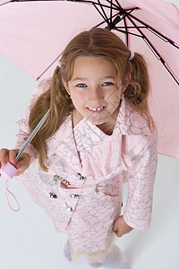 身穿雨衣的女孩拿着雨伞站着季节女性衣服下雨乐趣外套天气童年工作室女士图片