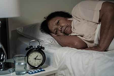 患有失眠症的老太婆想睡在床上药品卧室疾病压力悲伤疼痛苏醒老年说谎玻璃图片