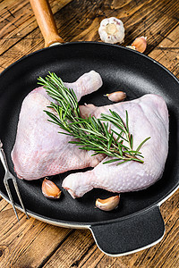 鸡腿生鸡腿在锅里 准备用于Grill木制背景桌子鸡肉胡椒大腿香料美食迷迭香木板白色食物图片
