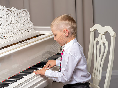画室里的小孩 在白色钢琴附近音乐家儿童乐趣童年幼儿园床单乐器音乐微笑黑色图片