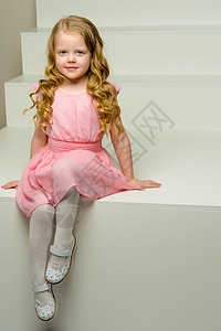 美丽的小女孩坐在白色的楼梯上 笑声教育童年粉色裙子享受工作室快乐乐趣阁楼孩子图片