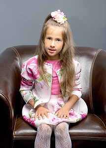 一个小女孩坐在皮革椅上 笑声儿童快乐白色剪裁交易女性绿色喜悦躺椅微笑图片