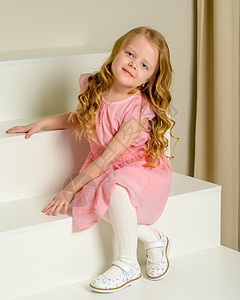 美丽的小女孩坐在白色的楼梯上 笑声乐趣阁楼享受粉色女性快乐孩子工作室裙子童年图片