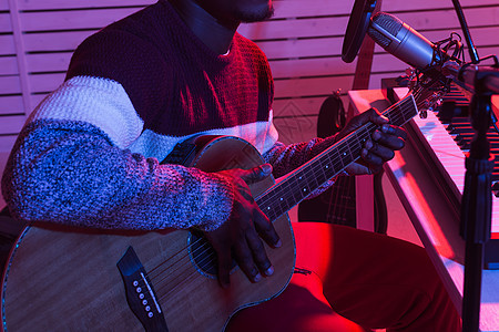 非洲专业音乐家在家中数码演播室录制吉他 音乐制作技术概念 特写节目 笑声吉他手键盘居住桌子手指训练工程师耳机工作室阳光图片