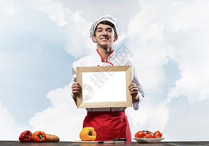 青年男厨师站在烹饪桌旁男性班级学校工人食物菜单美食职业厨房餐厅图片