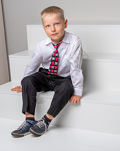 有个小男孩坐在白色的楼梯上城市房子孩子男性衣服女孩儿童脚步乐趣儿子图片