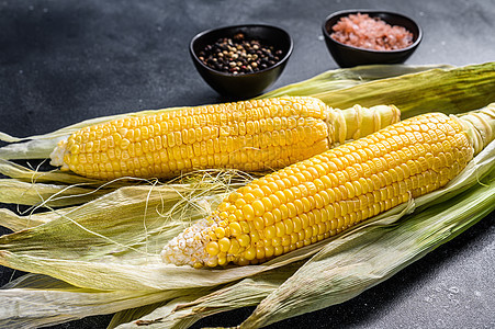 含盐和胡椒的鳕鱼上煮玉米 黑色背景粮食小吃玉米芯蔬菜野餐棒子黄色烧烤食物图片