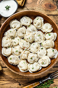 俄罗斯自制的Pelmeni 土豆 在木碗里吃牛肉和猪肉 木质背景洋葱白色美食水饺煮沸黑色食物桌子盘子午餐图片