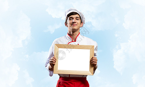 持有空白白板的年轻男厨师工作班级推介会职业天空菜单学校男性蓝色帽子图片