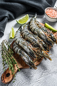 老虎海新鲜的老虎虾 有香料和草药的虾 在切削板上 灰色背景甲壳黑虎动物贝类食物海鲜国王背景