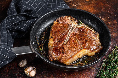 牛肉牛排 在锅中加草药 暗底背景 顶部视图鱼片炙烤食物迷迭香油炸木板胡椒盘子门房草本植物图片