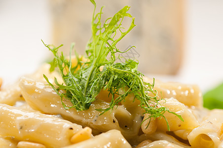 意大利通心粉戈贡佐拉和松子桌子坚果蓝色奶油菠菜盘子食物小麦产品羊乳图片
