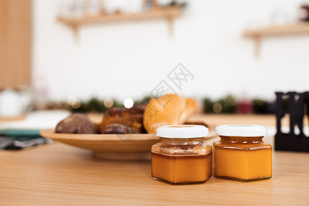 餐盘和蜂蜜罐上有饼干的厨房桌图片
