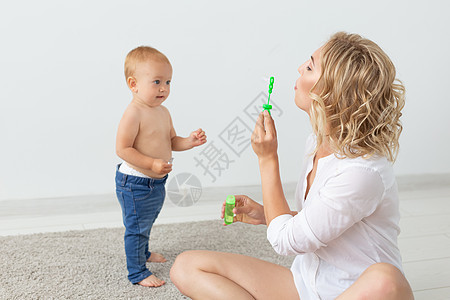家庭和为人父母的概念     可爱的婴儿在蜜蜂地毯上与母亲玩耍玩具成人女性幸福快乐孩子女士乐趣女孩生活图片