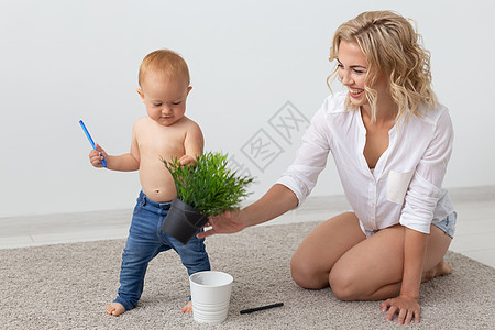 家庭 儿童和为人父母的概念快乐微笑的年轻母亲在家里和小婴儿玩耍育儿微笑地面男生女儿妈妈孩子乐趣母性女性图片