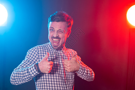 长着胡子的帅哥 穿着格子衬衫装蓝红背景 举起拇指 成功和良好选择的概念 笑声商务魅力运动头发红色男人英雄姿势推介会冒充图片