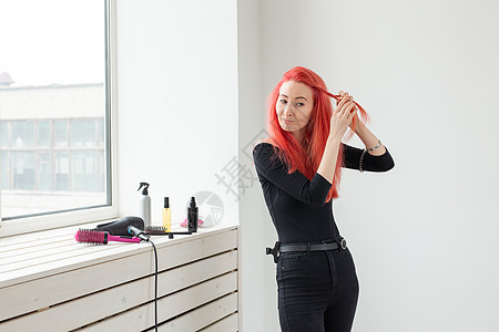 美丽的红头发女孩长发 在美容院里织着一副胸罩 专业的理发和制造发型造型师女性发胶发型设计理发师梳子疾病沙龙客户卷曲图片