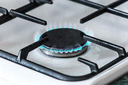 煤气炉炉子上放着蓝色火焰的煤气燃烧器 特制丙烷气体甲烷厨房圆圈炊具辉光烤箱烧伤滚刀图片