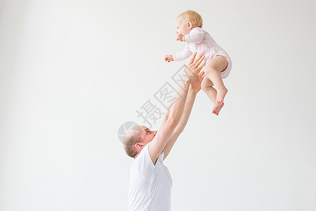 父亲举起女婴 快乐的父亲捡起并扔掉了一个小孩 家庭气氛 幸福的家庭笑着宝贝男人女儿乐趣童年生活爸爸喜悦飞行闲暇女孩图片