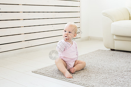 童年 儿童和婴儿期概念  可爱的金发婴儿坐在地板上眼睛幸福内衣身体地面女孩尿布快乐白色乐趣图片