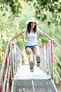 背着背包站在农村桥上的女人成人幸福森林活动乐趣旅游冒险女孩场地闲暇图片